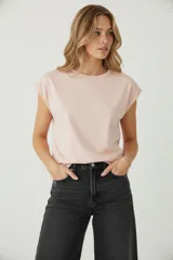 Remera blanca de algodón, de corte holgado, con cuello redondo a la base y mangas cortas con el dobladillo doblado hacia afuera.