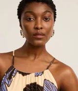 Vestido evasê largo midi de frente única, confeccionado en viscosa, con estampado de hojas en tonos beige, negro y celeste.