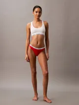 Bombacha tipo colaless de la línea Modern Logo de Calvin Klein, confeccionada en mezcla de algodón elástico. Presenta un diseño de talle medio con bordes planos y la icónica cinturilla elástica distintiva de la marca con el logo estampado.