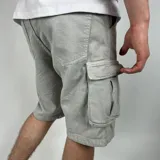 Bermuda de jean color gris claro con bolsillos cargo laterales.