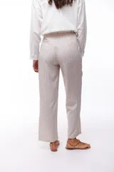 Pantalón de vestir color beige con rayas verticales blancas, de corte ancho y tiro alto.