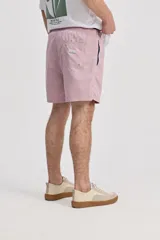 Short de baño azul, de corte clásico y largo corto, con cintura elástica y cordón ajustable bicolor. Cuenta con bolsillos laterales y uno trasero.