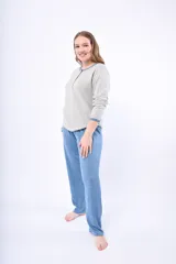 Pijama de dos piezas color coral, confeccionado en lanilla. Incluye una camisa de manga larga con botones y un pantalón largo.