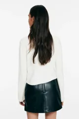 Saco corto de punto jacquard, color blanco con estampado de rombos en gris. Presenta cuello redondo, cierre frontal con botones y terminaciones acanaladas en puños y bajo.