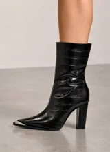 Bota de caña media en cuero genuino con textura de reptil, color negro. Presenta punta fina con puntera metálica plateada y taco cuadrado alto.
