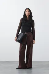 Pantalón wide leg color marrón chocolate, de tiro medio y corte relajado. Presenta detalle de hebillas laterales con ojales metálicos en la cintura y una caída fluida.