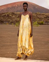 Vestido largo y fluido de seda lúrex en color amarillo, con estampado inspirado en pañuelo, escote en V, tirantes ajustables y bajo con volante.