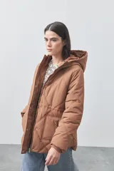 Campera puffer negra con diseño acolchado, capucha integrada y cierre frontal con botones a presión. Presenta puños elásticos y costuras decorativas en el frente.