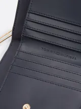 Billetera Tommy Hilfiger color beige con cierre de cremallera y logo de la marca en dorado.