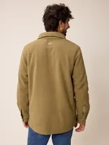 Sobrecamisa de polar azul marino con cierre frontal de botones a presión. Presenta bolsillos frontales con solapa, uno de ellos con cierre de cremallera adicional y detalles en contraste de material técnico.