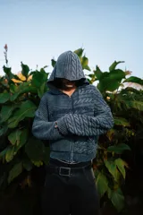 Campera de punto de doble textura y cierre frontal completo con capucha, de color gris oscuro, con bolsillos tipo canguro y el nombre de la marca bordado en el pecho.