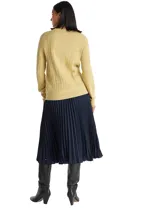 Sweater de manga larga color verde claro, con cuello redondo y tejido de punto trenzado (cable knit) vertical. Presenta un pequeño logo bordado en el pecho.