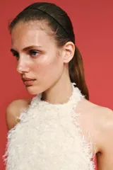Vestido corto de textura peluda con flecos, diseño de cuello halter y espalda descubierta.