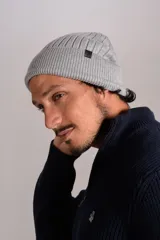 Gorro tipo beanie de tejido acanalado en color gris, con etiqueta pequeña con logo en el lateral.