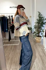 Pantalón de jean azul oscuro con corte wide leg, tiro alto y costuras verticales decorativas en el frente. Presenta un ruedo desflecado y un diseño de pierna ancha.