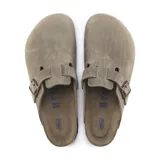 Zueco Birkenstock modelo Boston de cuero engrasado, color marrón topo (taupe), con una tira ancha ajustable con hebilla metálica en el empeine, suela de corcho y plantilla anatómica.