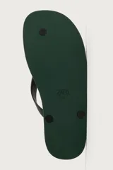 Sandalia de goma color negro, de diseño plano y tiras delgadas en el empeine estilo ojota.