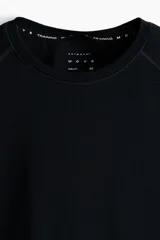 Remera deportiva negra de manga raglán con cuello redondo y costuras planas, diseñada con ajuste Muscle Fit y tejido funcional transpirable.