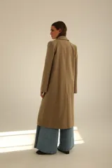 Tapado largo de paño en color beige, con solapas clásicas, cierre frontal de dos botones y corte recto estructurado.