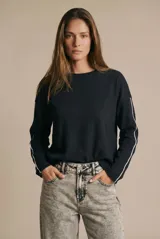 Sweater de algodón negro con calce oversize, cuello redondo y mangas largas con detalle de línea blanca lateral.