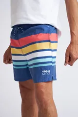 Short de baño con cintura elástica y cordón ajustable, confeccionado en tela ligera de secado rápido. Presenta un estampado botánico integral en tonos amarillos, blancos y azules, con dos bolsillos delanteros y uno posterior.
