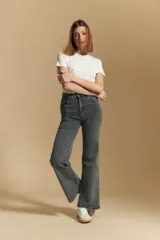 Jean de tiro alto con corte recto, confeccionado en denim con spandex. Presenta un lavado gris oscuro con efecto desgastado, cierre frontal con botón y bolsillos laterales y traseros.