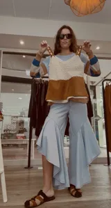 Pantalón de jean azul oscuro con diseño fluido y volados en las piernas.