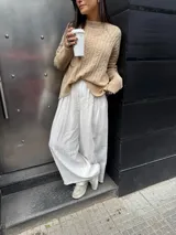 Pantalón sastrero marrón de corte palazzo, con botón, pasacinto y pretina trasera con elástico.