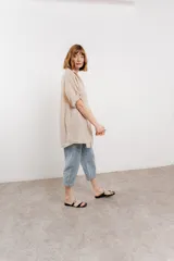 Camisa amarilla de lino, de corte recto y calce suelto. Presenta cuello camisero, botones en el frente y mangas cortas con presilla y botón.