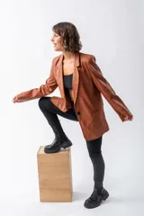 Blazer color marrón de eco cuero, con solapas definidas, corte entallado y puños ajustables.