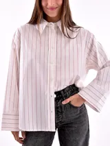 Camisa blanca a rayas verticales color ladrillo, de corte recto y mangas largas con puños abotonados.