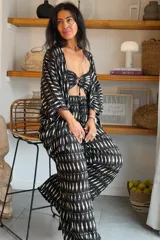 Conjunto de tres piezas de algodón con estampado abstracto en blanco y negro, compuesto por un kimono abierto de manga corta, un top estilo bandeau con nudo frontal y un pantalón largo de corte holgado.