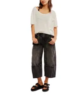 Pantalón de jean negro con lavado gastado, corte ancho, tiro alto, bolsillos delanteros y traseros, y terminación con dobladillo ancho.