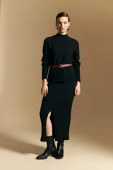 Polera de cuello alto confeccionada en tejido de punto negro, con diseño de textura acanalada en cuello, puños y ruedo, y trama vertical en mangas y espalda.