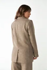 Blazer largo color crema con cuello solapa, bolsillos con solapa y forro interior combinado a tono. Confeccionado en lana fina sin teñir.