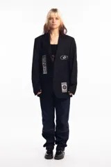 Blazer negro con parches y estampado en serigrafía.