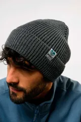 Gorro de lana tipo beanie de tejido acanalado, color blanco, con vuelta y pequeña etiqueta circular con el logo de Umbro en el lateral.