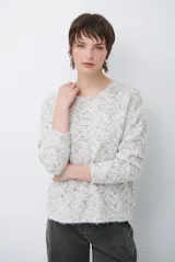 Buzo de tejido de punto con textura jaspeada en tonos claros, cuello redondo, mangas largas y corte recto.