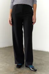 Pantalón negro de corte recto y pierna ancha, con cintura alta, bolsillos laterales y cierre.