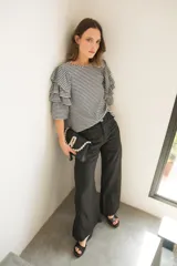 Pantalón de corte wide leg y tiro medio, confeccionado en lino. Presenta diseño de pierna ancha, cierre frontal con botón y bolsillos laterales.