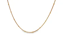 Collar de acero con baño en oro amarillo, diseño de cadena fina adornada con pequeñas cuentas esféricas espaciadas uniformemente.