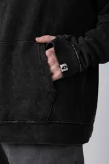 Buzo canguro de corte oversize en color verde con efecto de teñido desgastado. Cuenta con capucha, bolsillo frontal tipo canguro y puños acanalados.