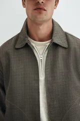 Campera con cuello, cierre oculto frontal, bolsillos insertados delanteros y bolsillo interior. Mangas largas con puños abotonados y trabilla ajustable con botón en los laterales del bajo.