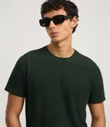 Remera de corte regular confeccionada en tejido piqué de algodón, con cuello redondo y manga corta. Presenta un diseño liso y minimalista con textura sutil.