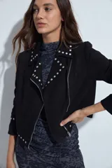 Campera estilo biker de gamuza sintética color negro, con solapas decoradas con tachas metálicas plateadas y cierre frontal cruzado.