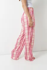 Pantalón de pijama celeste con rayas verticales finas color marrón, con bolsillos laterales y elástico en la cintura.