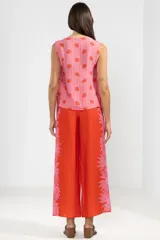 Musculosa liviana de viscosa y poliamida con estampado floral, lazos en los costados y calce ajustable.