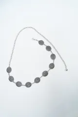 Cinturón de cadena plateada con eslabones circulares texturizados y cierre de mosquetón ajustable.