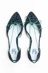 Bailarinas con aberturas laterales, de raso flocado verde botella. Cuentan con cordones del mismo tono para atar y plantilla de lana.
