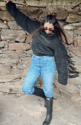 Sweater tejido a mano en lana merino color negro con flecos en las mangas.